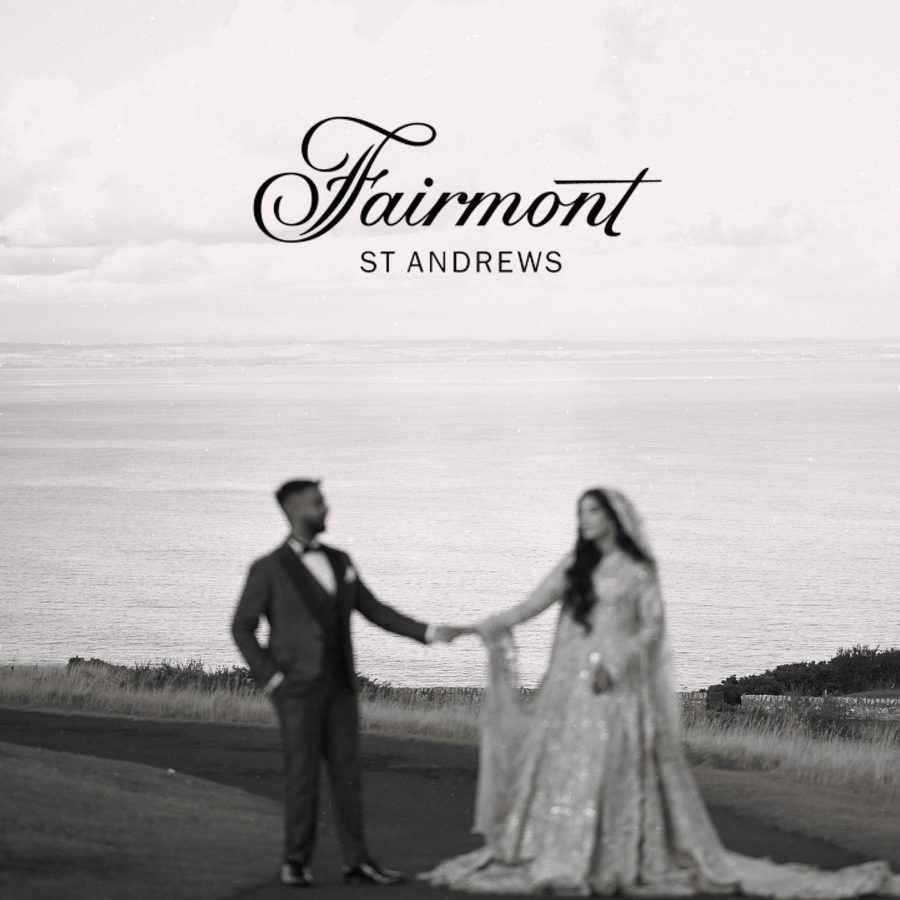 Bride and groom holding hands on a coastal headland