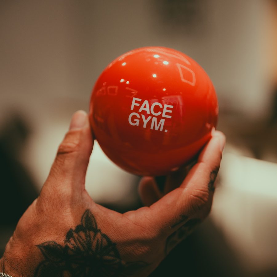 Hand holding a branded red ball, brand event detail